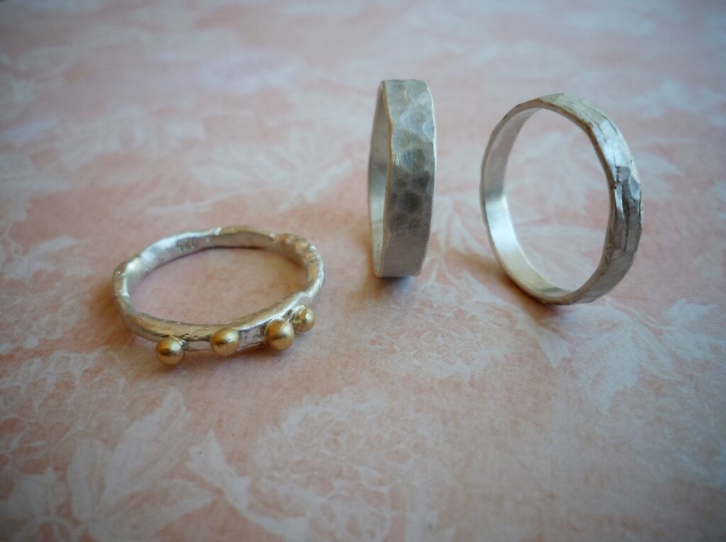 An organic sterling silver ring with 14k yellow gold granules and two hammered sterling silver bands.