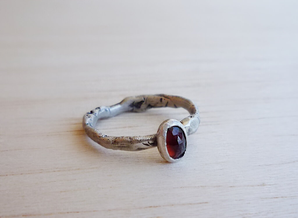 A custom-made ring with a wonderful, glowing rose cut garnet, plus a custom pendant with stamped stars and engraved letters.