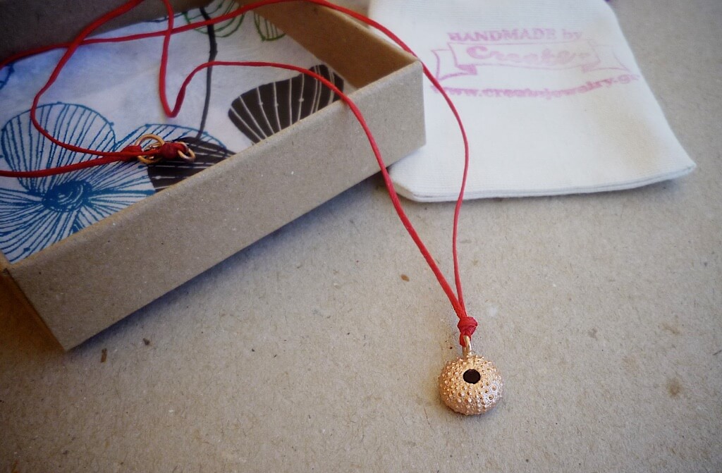 A rose gold plated version of the small urchin pendant and the large sterling silver urchin with silk cord.